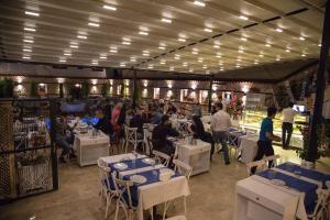 a group of people sitting at tables in a restaurant at Kervan Hotel in Antalya