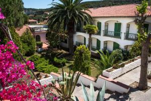 uma vista para um edifício com flores e árvores em Hotel Marelba em Cavo