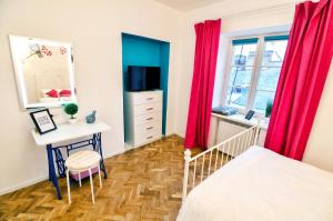 - une chambre avec des rideaux rouges, un bureau et un lit dans l'établissement Stylish apartment. Heart of the city, à Lviv