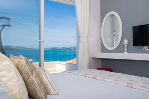 a bedroom with a bed with a large window at Apartments Soho in Trogir