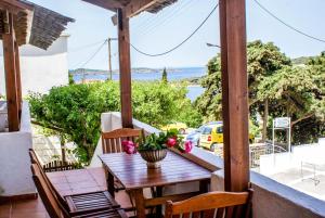 a table on a balcony with a view of the ocean at Amorani Studios in Batsi