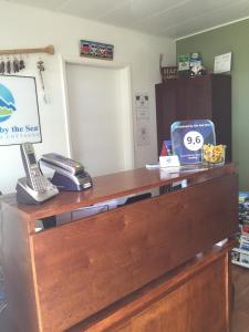 a reception desk with a phone on top of it at Driftwood by the Sea Inn in Campbell River
