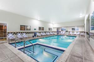 une piscine avec des chaises et des tables dans un hôtel dans l'établissement Days Inn by Wyndham Hershey, à Hershey