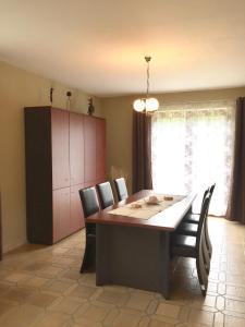 a dining room with a table and chairs and a cabinet at Le Valdine in Jemeppe