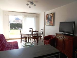 a living room with a dining table and a television at Clos Fleuri in Berck-sur-Mer