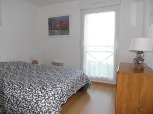 biała sypialnia z łóżkiem i oknem w obiekcie Clos Fleuri w mieście Berck-sur-Mer