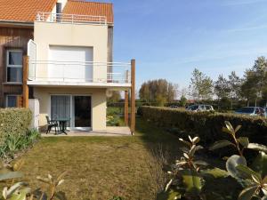 ein Haus mit einem Balkon und einem Hof in der Unterkunft Clos Fleuri in Berck-sur-Mer