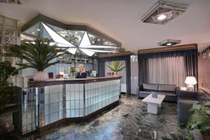 a lobby of a hotel with a woman at a counter at Xenophon Hotel in Athens