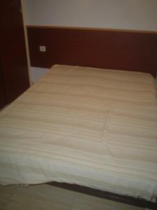 エンプリアブラバにあるSylviaの白いベッドシーツが備わるベッドルームのベッド1台