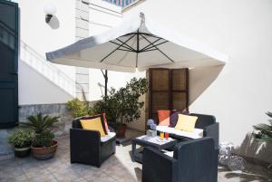 un patio con due sedie e un ombrellone di Le Tre Rose di Giò a Casamassella