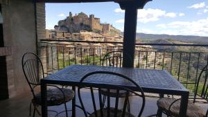 a table and chairs on a balcony with a view of a castle at Casa Sampietro in Alquézar