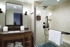 a bathroom with a shower, sink, and mirror at The Perry Hotel & Marina Key West in Key West