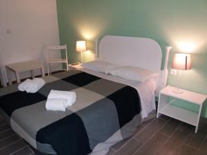 ヴィラ・ノヴァ・デ・ミルフォンテスにあるAlojamentos Vitinho 2 - Vila Nova Milfontesのベッドルーム1室(大型ベッド1台、タオル付)