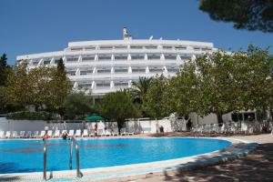 a hotel with a swimming pool in front of a building at Hotel Villaggio Club Altalia in Brancaleone Marina