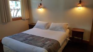 a bedroom with a bed with two pillows and a window at Whakatane Hotel in Whakatane
