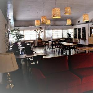 Un comedor con mesas, sillas y luces. en Hotel La Fundacion, en General Roca