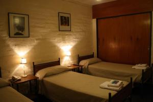 Una habitación de hotel con dos camas y dos lámparas. en Hotel La Fundacion, en General Roca