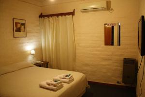 Una habitación de hotel con una cama con toallas. en Hotel La Fundacion, en General Roca 16 fotos más