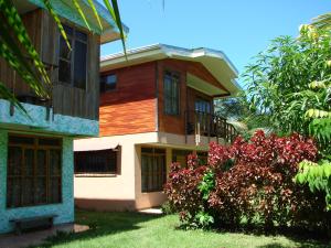 un bâtiment avec des arbres et des fleurs devant lui dans l'établissement Babilonia, à Cahuita