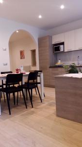 Paganella Apartment في مولفينو: مطبخ وغرفة طعام مع طاولة وكراسي