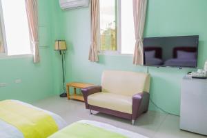 a living room with a chair and a tv at Just Stay 稼軒 in Yuanshan