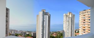 deux grands bâtiments blancs dans une ville avec un ciel bleu dans l'établissement Apartment Andrej, à Rijeka