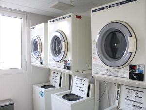 two washing machines and a washer and dryer in a room at Green Rich Hotel Tosu Ekimae in Tosu
