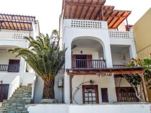 a house with a palm tree in front of it at Amorani Studios in Batsi