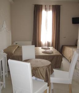 a room with two beds and a table and chairs at B&B Le Giare in Monterosso al Mare