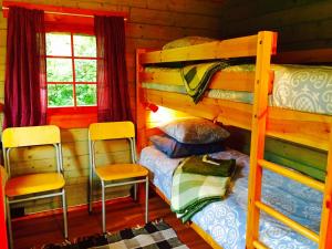 a bedroom with two bunk beds and two chairs at Kuivastujaani in Kuivastu