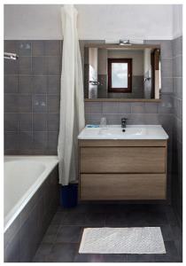 a bathroom with a sink and a tub and a mirror at La Bonne Auberge in Risoul