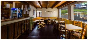 a restaurant with tables and chairs and a bar at La Bonne Auberge in Risoul