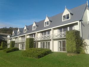 un gran edificio blanco con techo gris en Admirals Motor Inn, en Nelson