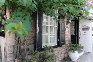 a brick house with a black door and a window at To Spitaki Apartments in Galaxidhion