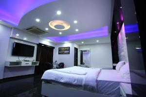 sypialnia z dużym łóżkiem i telewizorem w obiekcie Hotel RR International w mieście Bengaluru