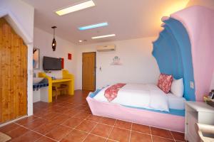 a bedroom with a bed and a desk in a room at Haisu Homestay in Eluan