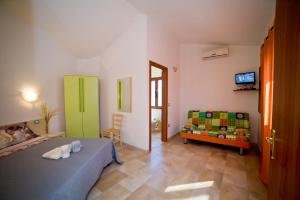 a bedroom with a bed and a couch and a television at Casa Museddu in Cardedu