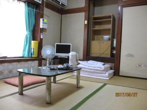 a room with a table and a computer in it at YOKOSO Ryokan in Beppu