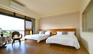 um quarto com 2 camas e uma grande janela em Residents with easy places em Taitung City