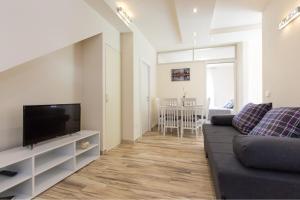 uma sala de estar com um sofá e uma televisão de ecrã plano em Apartman Fortica em Opatija