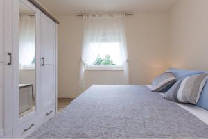 um quarto com uma cama grande e uma janela em Apartman Fortica em Opatija