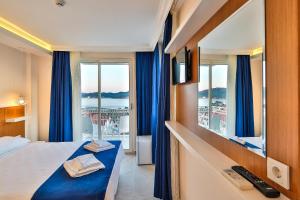 a hotel room with a bed and a large window at Kaş Artemis Hotel in Kas