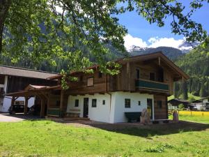 a log cabin with mountains in the background at Chalet am Müllergut in Sankt Martin bei Lofer