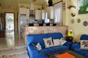 a living room with a blue couch and a kitchen at Can Tapsy in Tossa de Mar