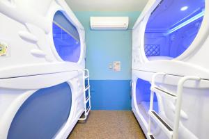 Pokój z niebieskimi ścianami i białymi łóżkami piętrowymi w obiekcie Earth Village B&B w mieście Hualian