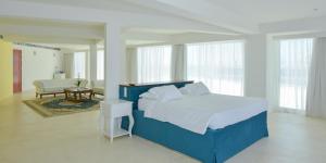 a bedroom with a blue bed and a living room at Ibiscus Hotel in Rhodes Town