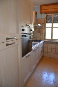 kuchnia z białymi szafkami i piekarnikiem w obiekcie Vacanze Sardegna Mare San Giovanni Posada w mieście Posada