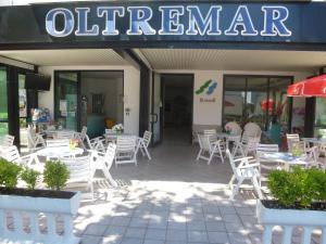カットーリカにあるB&B Hotel Oltremarの白い椅子とテーブルが前に並ぶレストラン