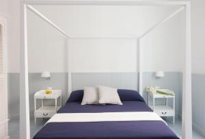 a bed in a bedroom with a white bedspread at I Pretti Resort in Favignana