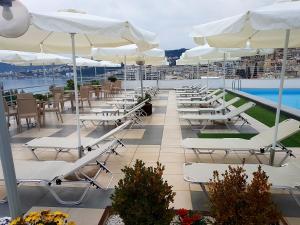 a row of white chairs and umbrellas on a roof at Oceanis Hotel in Kavála
